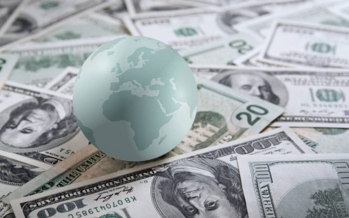 Earth globe on heap of money
